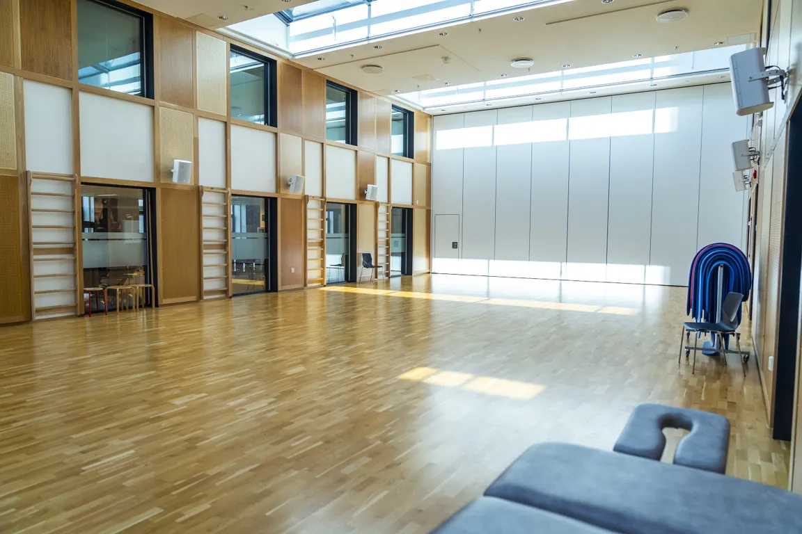 Et rom med tregulv og en blå stol