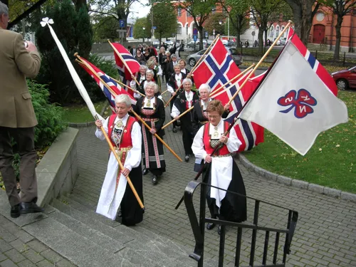 Tog med flagg og faner fra festgudstjeneste til festmiddag. Jubileumsåret 2006