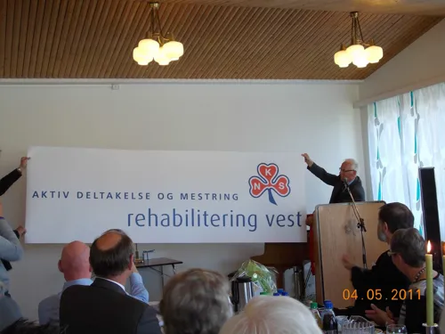 Administrerende dirketører fra Helse vest og HSR erklærer Rehabilitering Vest for åpnet ved å henge opp banner, mai 2011