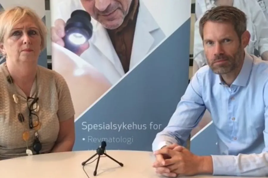 En mann og en kvinne som sitter ved et bord med mikrofon