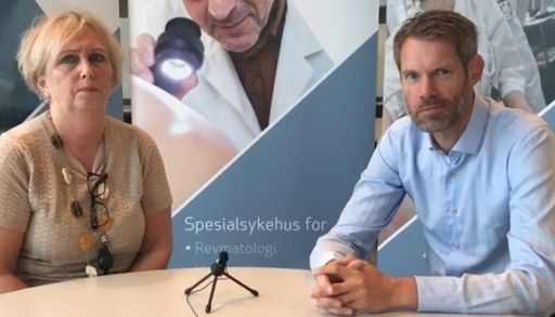 En mann og en kvinne som sitter ved et bord med mikrofon