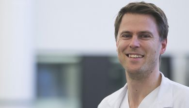 En mann som smiler til kameraet