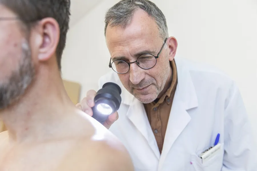 Lege foretar hudundersøkelse