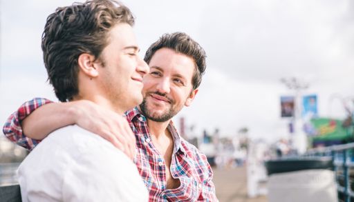 En mann med armen rundt en annen manns skulder